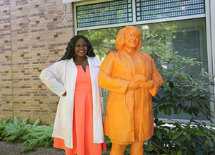 Dr. Lataisia Jones posing with her 3D printed statue