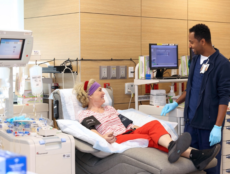 A clinican assists a patient in bed.