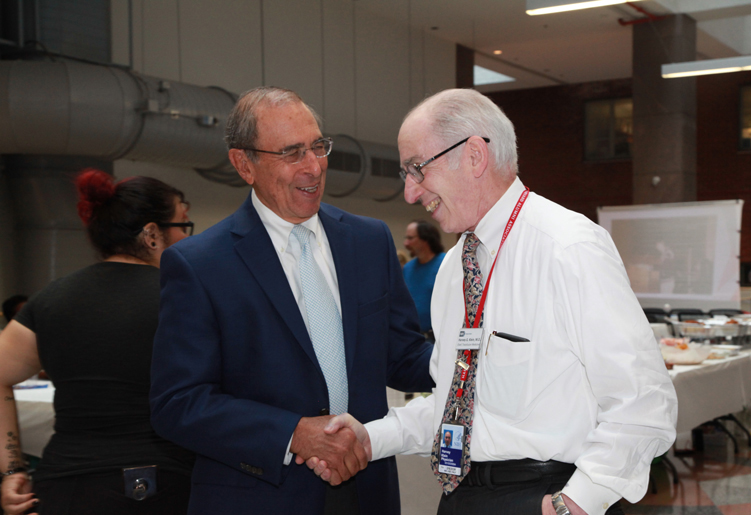 Dr. John I. Gallin shakes Dr. Harvey Klein's hand