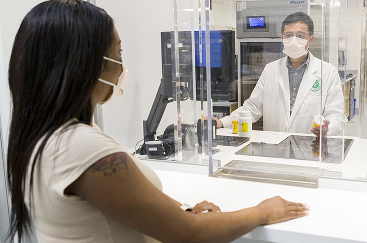 Woman picking up prescription from Clinical Center Pharmacy