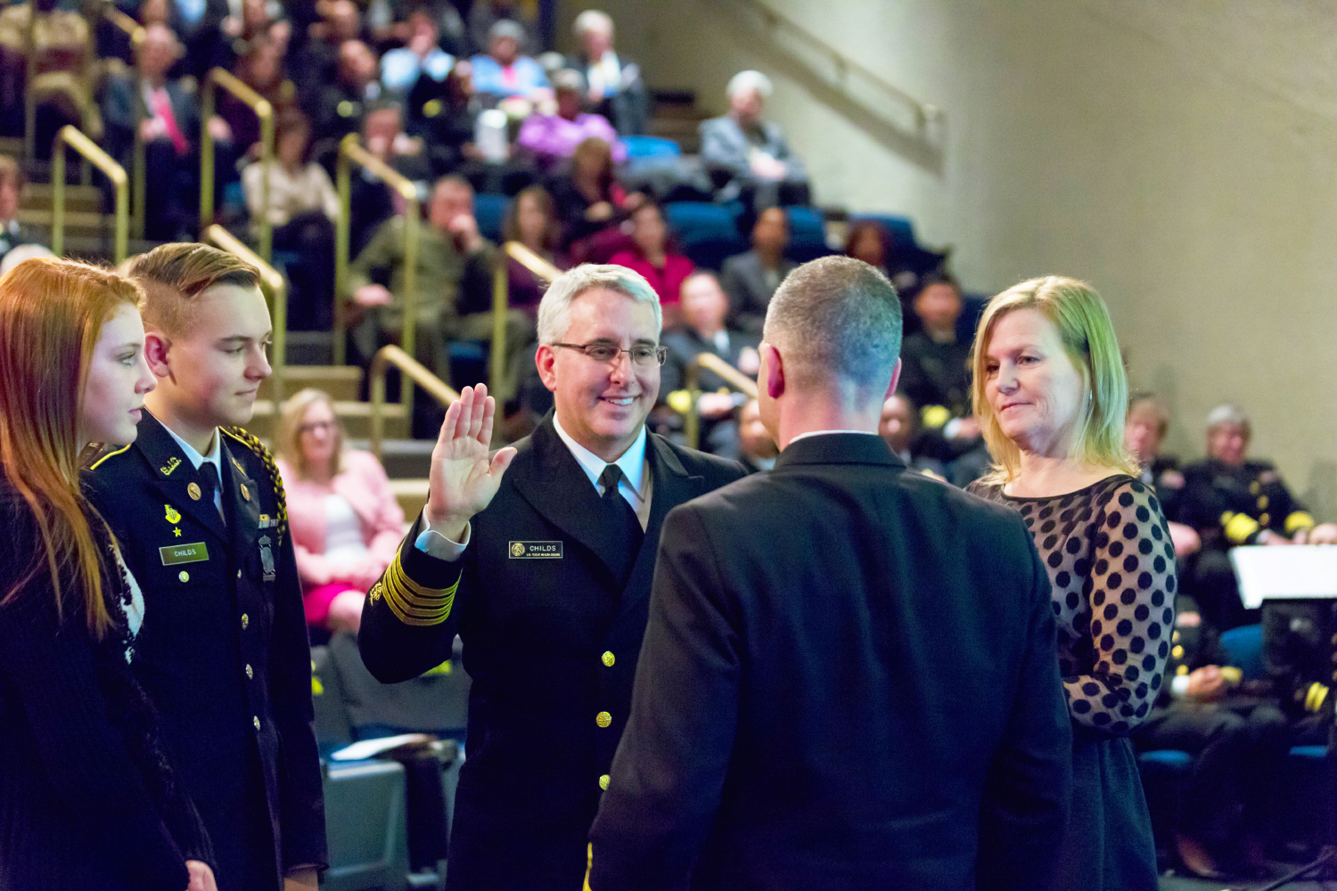 Dr. Richard W. Childs, joined by his wife, son and daughter, says the oath of office.