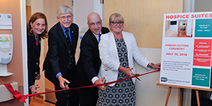 Senior leaders at NIH cut a ribbon opening two hospice suites at the Clinical Center