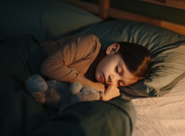 A young child sleeping peacefully in a cozy bed
