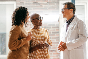 Physician discussing a treatment plan with 2 patients