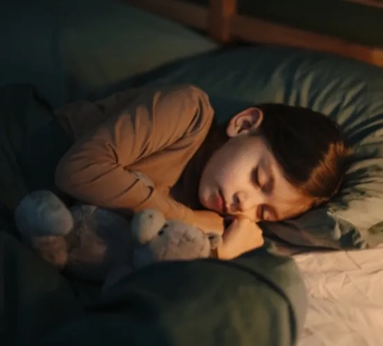 A young child sleeping peacefully in a cozy bed