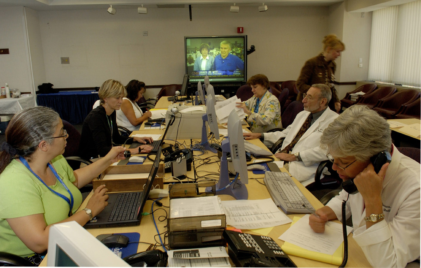 NIH Clinical Center staff (from left), Dinora Dominguez, Laura Lee, Dora Bell, Nancy Jenkins, Debra Byram, Dr. Fred Gill and Kathie Bronson answer and triage calls in the NIH Call Center. 
