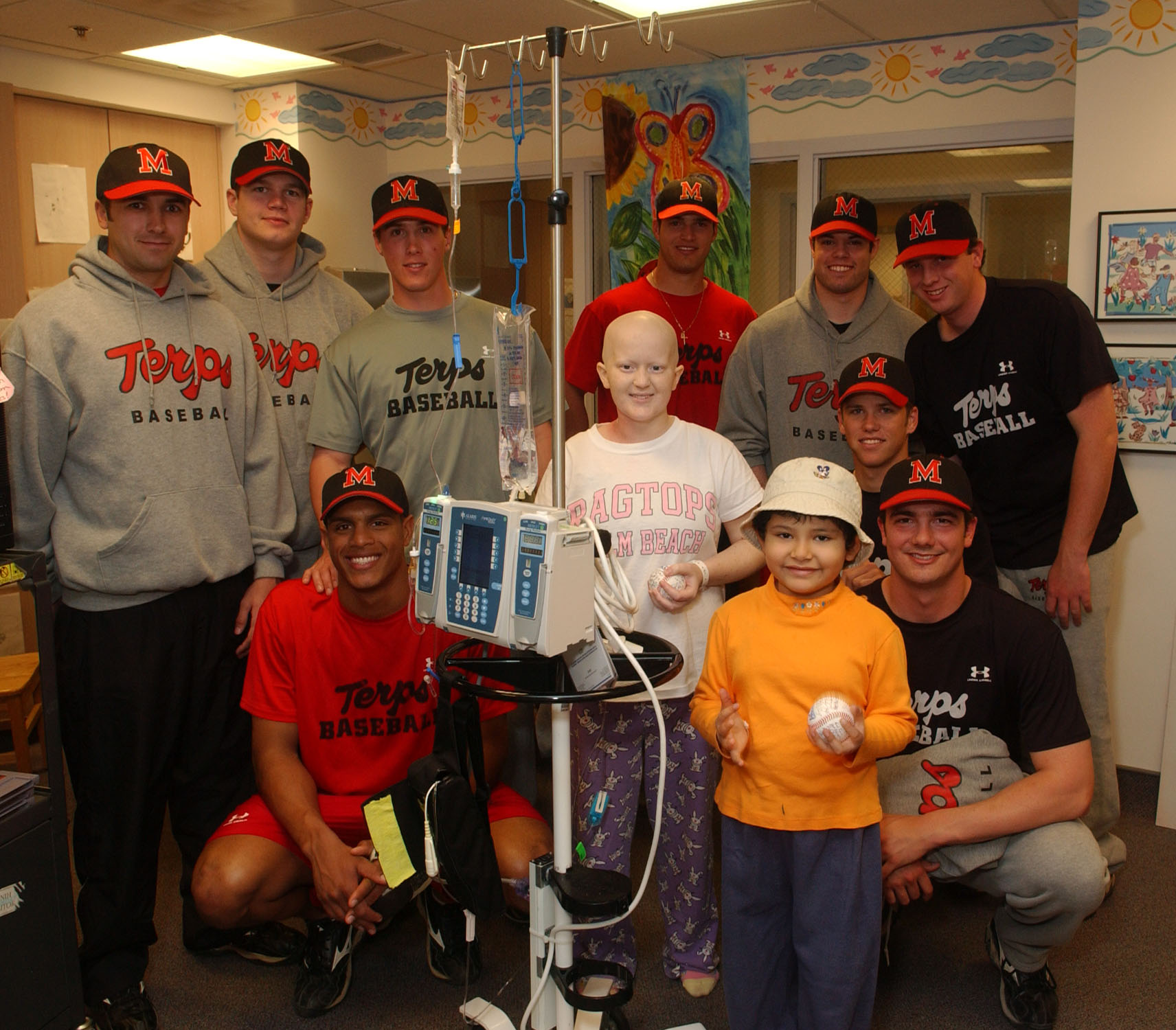 The Maryland Terrapins baseball team with pediatric patients Amy Knopfmacher (left) and Valeria Rivero, on one of their CC visits.