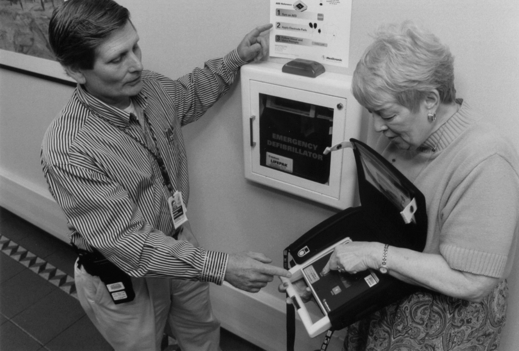 Photo of Fredrick Manuel and Jerry Taylor demonstrating the defibrillator