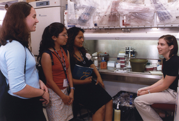 photo of three native american youth speaking to a summer research fellow