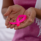 hands holding pink ribbon