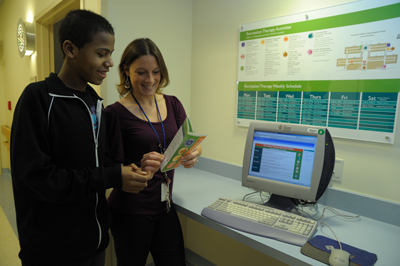 Recreation therapist showing a patient the new calender format