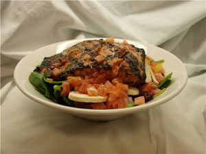 salmon on a bed of greens in a bowl