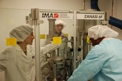 PDS staff adjust a capsule-making machine