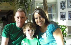 Stem-cell transplant survivor poses with his wife and son at a return trip to NIH