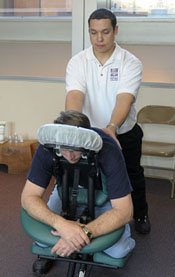 Masseuse stands behind man on massage chair
