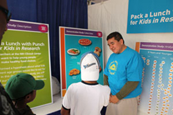 Omar Echegoyan talks to young visitors to the Clinical Center Science Festival booth.