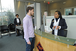 A patient visitor is greeted by a CC hospitality staff member
