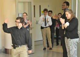 the NIH-Project SEARCH team applauding Christopher Herron as he was entering his class' graduation