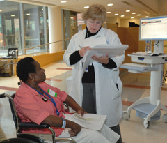 A medical professional and a patient with paper work in their hands.
