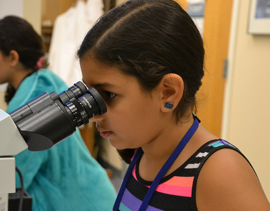 Jada Mahoney looking through a microscope