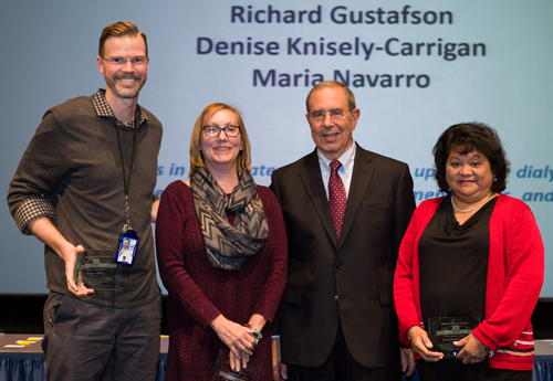 Richard Gustafson, Denise Knisely-Carrigan and Maria Navarro receive an award at the Annual Address and Awards Ceremony on Dec. 18, 2016.
