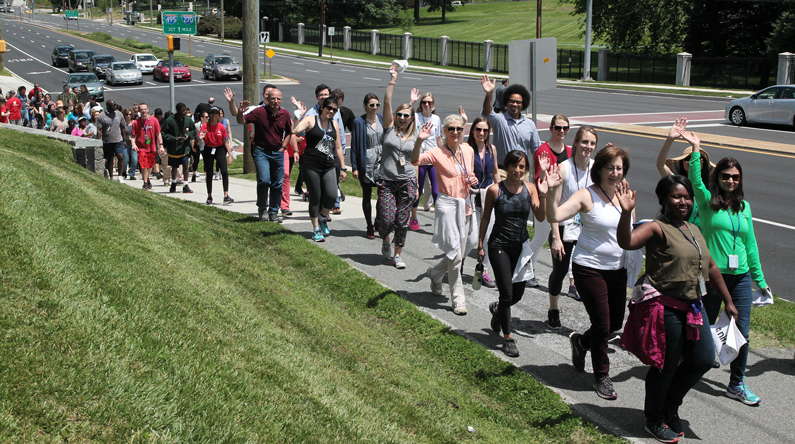 NIH staff wave at the camera on NIH Take a Hike day