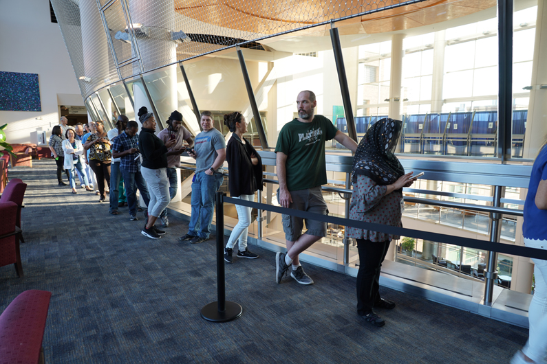 About 14 people stand in line, wrapped around the 7th floor hallway above the atrium for the flu vaccine clinic to open on its first day, Oct. 1.