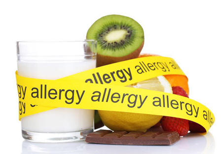 Image of milk glass, kiwi and other food wrapped with a yellow banner that says allergy