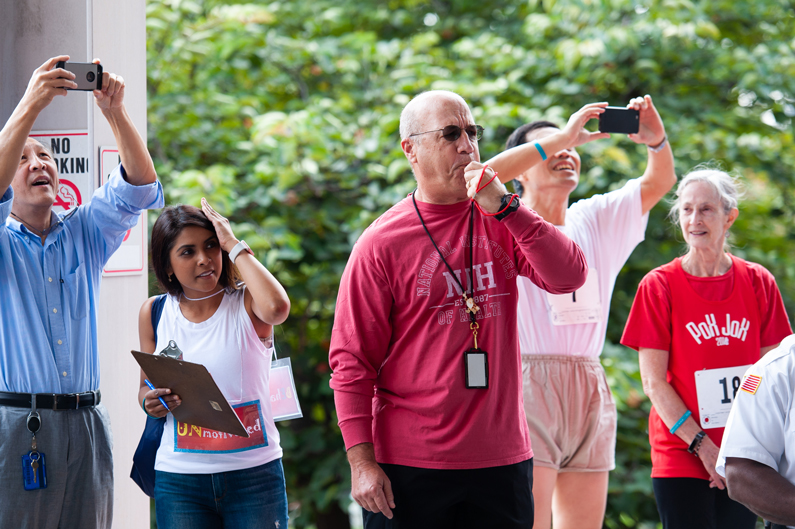 Dr. Jim Gilman, Clinical Center CEO, blows a whistle as they get the runners off to a start during a heat