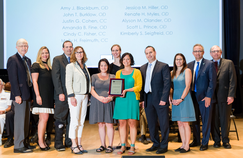 First in Human Documentary Group award recipients on stage. Pictured from the Clinical Center, Molly Freimuth (fifth from right) and Justin Cohen (fourth from right)