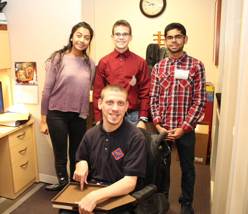 Three students from Poolesville High School gather with NIH employee Ricky Day
