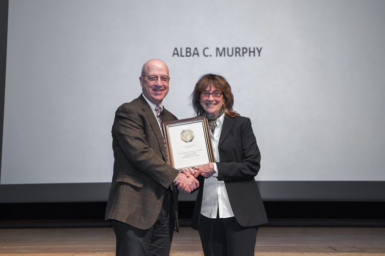 Dr. James Gilman stands with Alba C. Murphy as they smile and hold a certificate