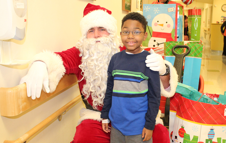 Santa visits with one of the Clinical Centers youngest patients, in the pediatric unit