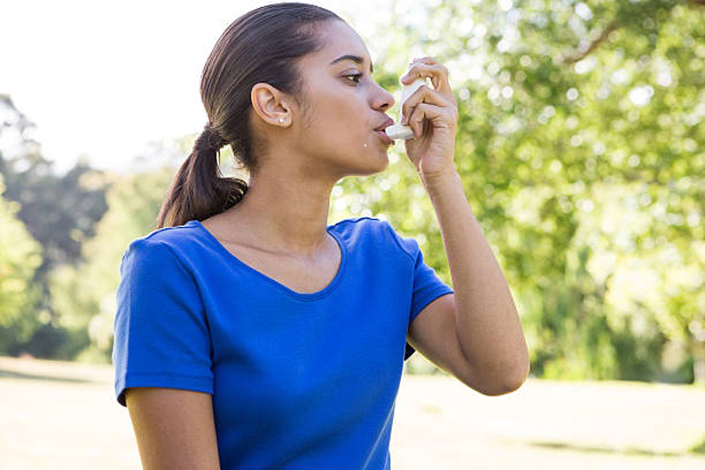 A woman using asthma inhaler