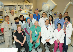 Interventional Radiology doctors, nurses, technologists, and staff in front of the Artis Zeego multi-axis CT system which was recently installed in one of the Interventional suites