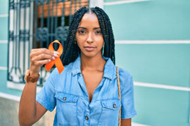 a woman holding an an orange ribbon