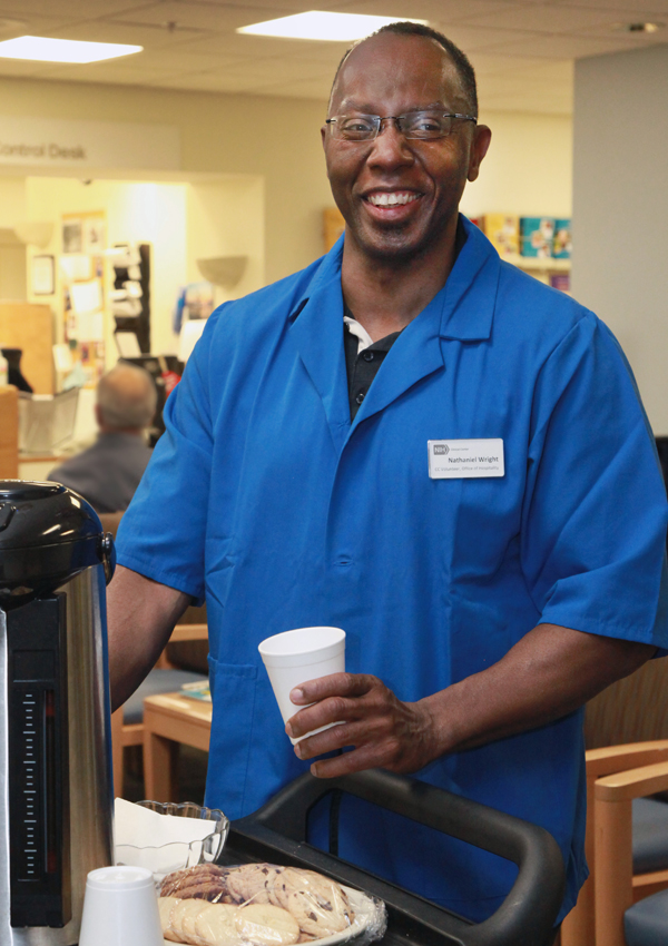 A smiling volunteer gets coffee.